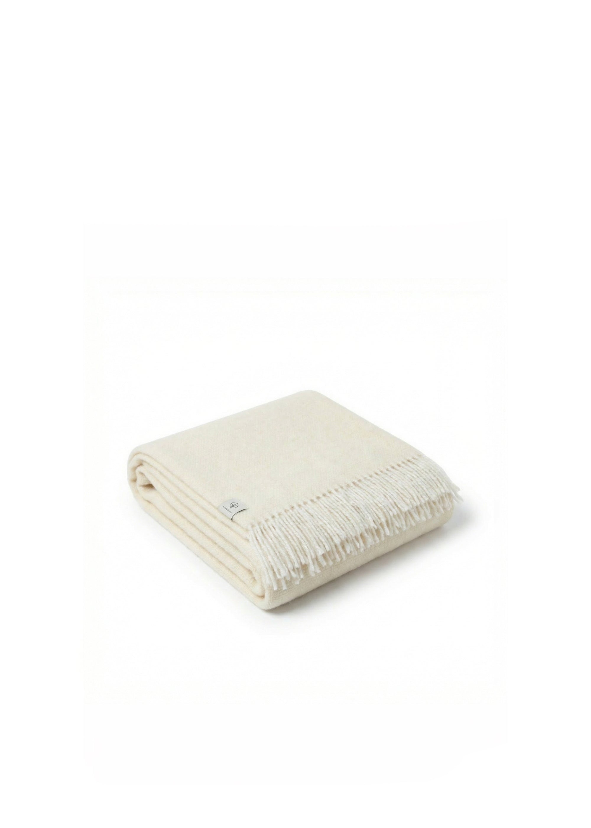 Cream wool throw blanket with fringed edges draped over a wooden chair