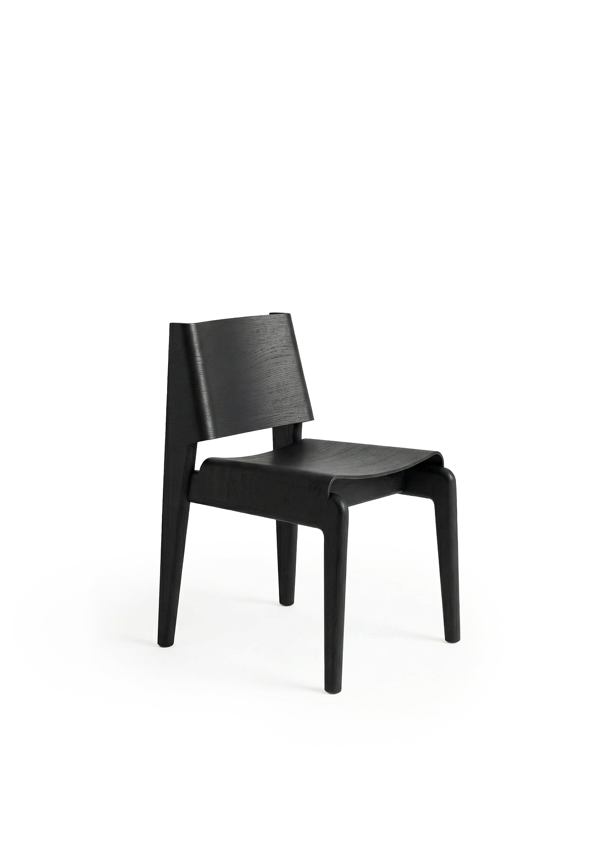 A wooden chair with a curved backrest and angled legs placed in a dimly lit industrial space.