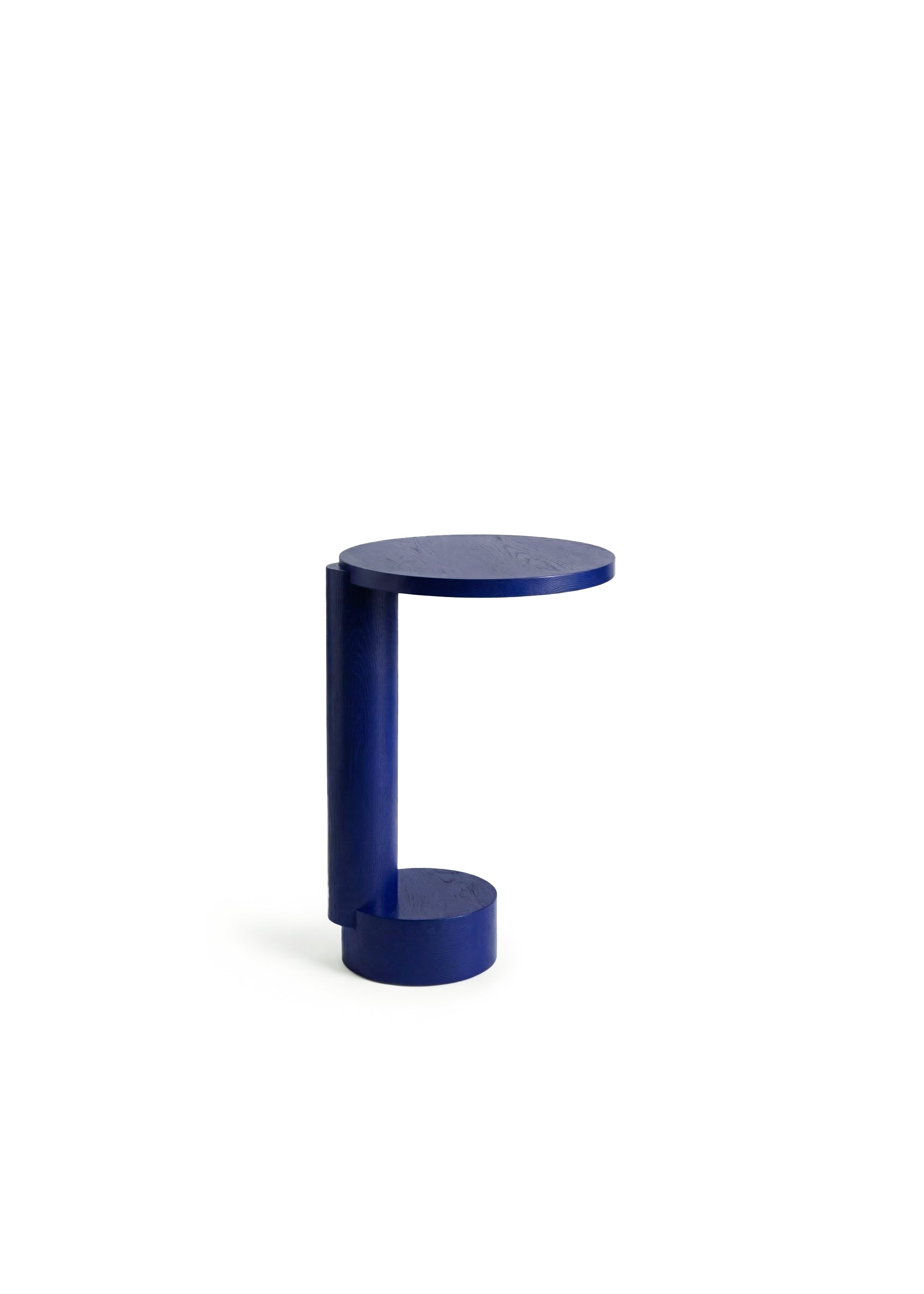 Blue modern side table placed next to a cream sofa in a bright interior.