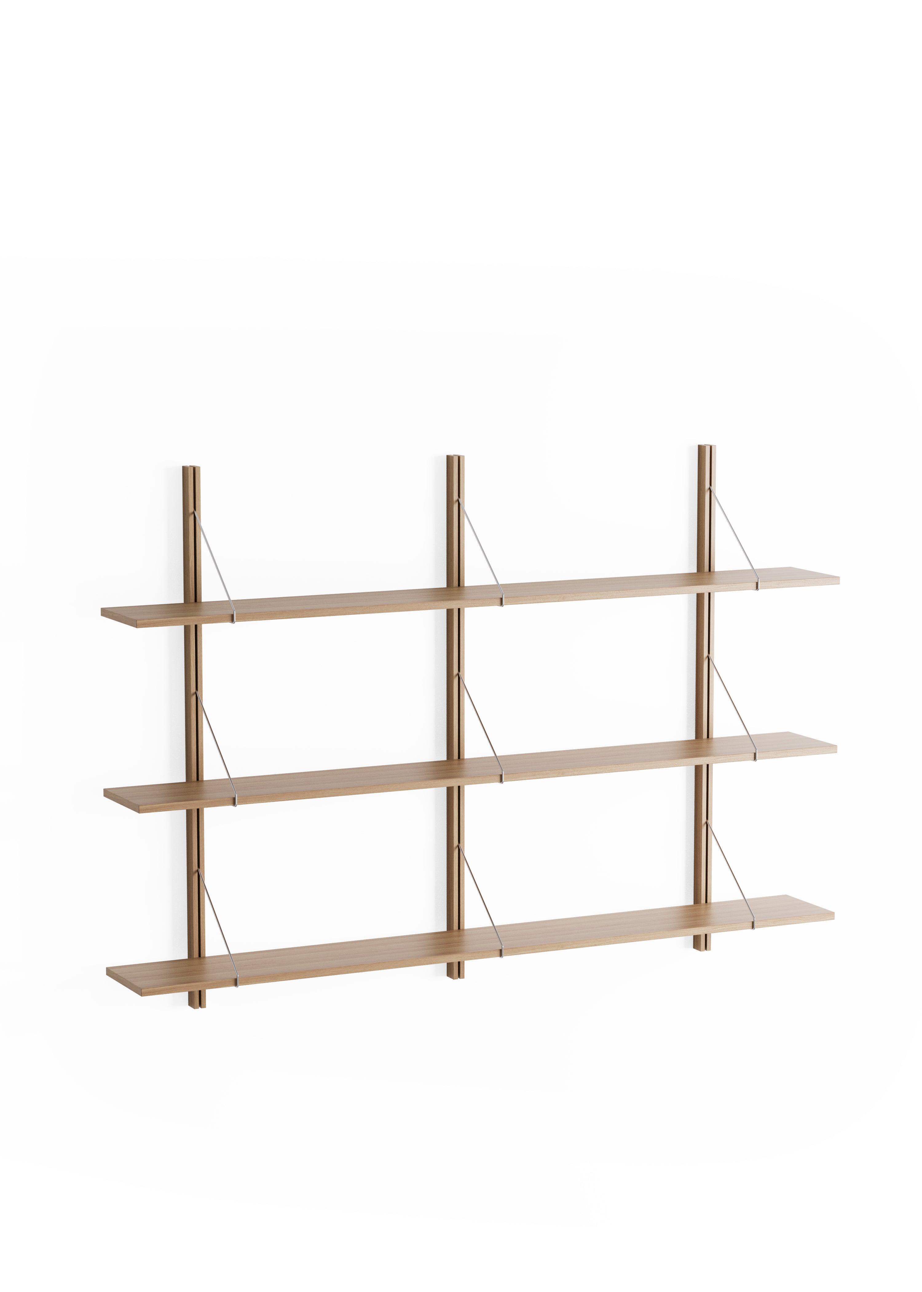 A bookcase with wooden shelves above a light-coloured sofa and lamp