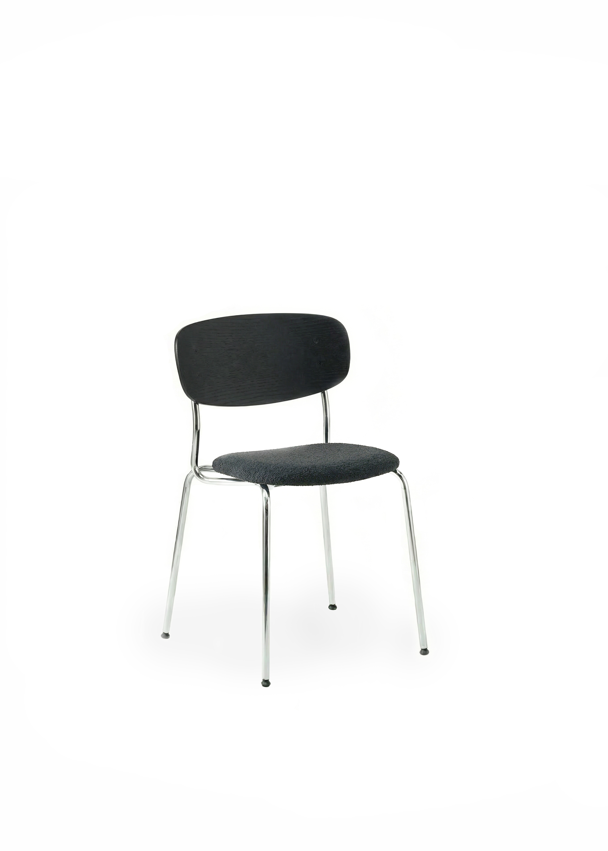 Black dining chair with a curved backrest and chrome legs positioned beside a dark wooden table with fluted legs, in front of sheer curtains